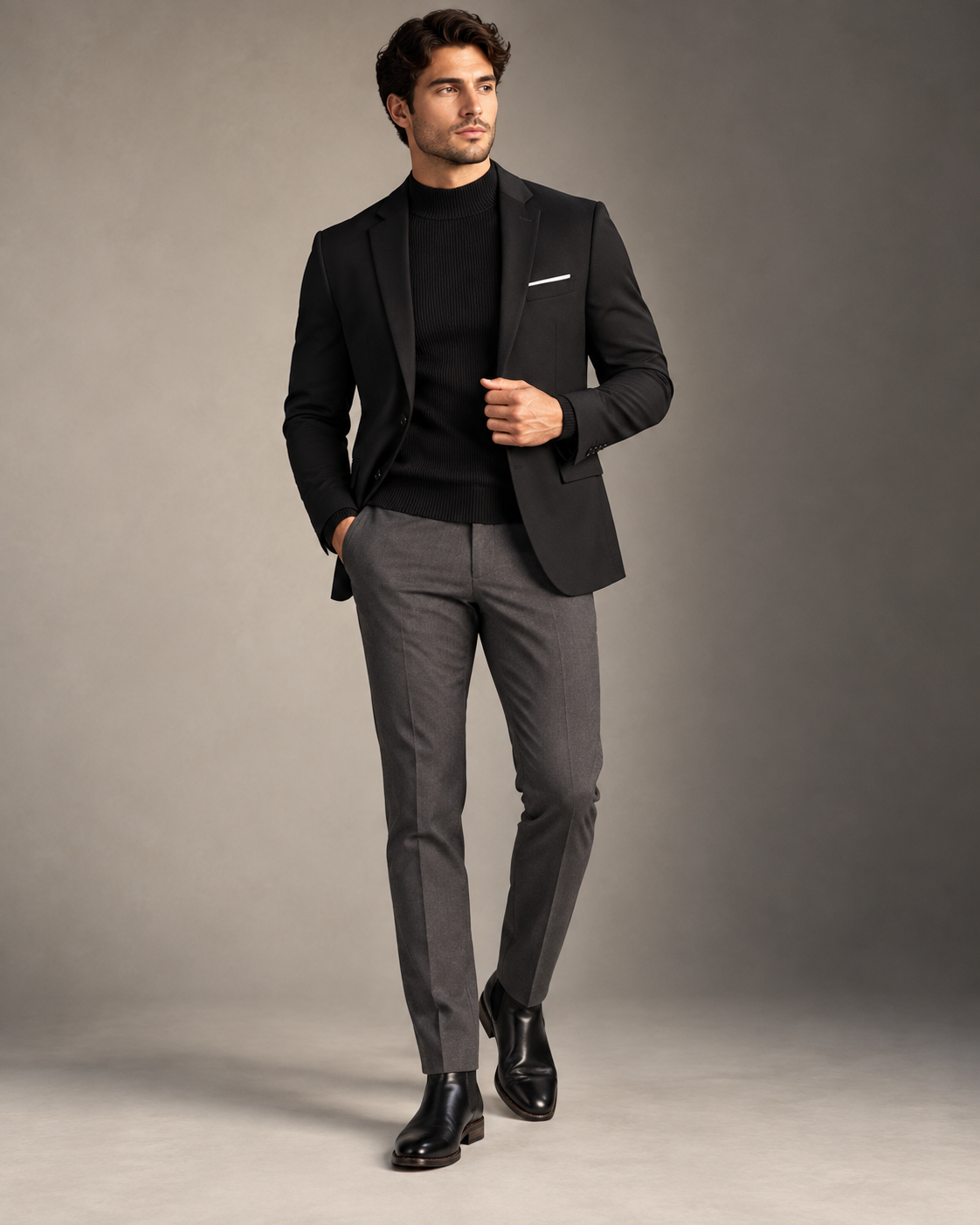 Man wearing a black blazer and turtleneck with tailored gray trousers